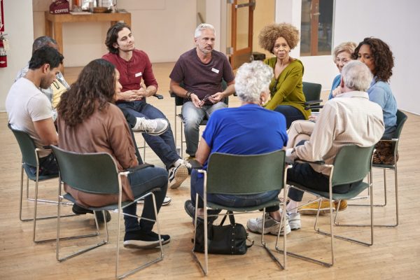 People Attending Self Help Therapy Group Meeting In Community Center